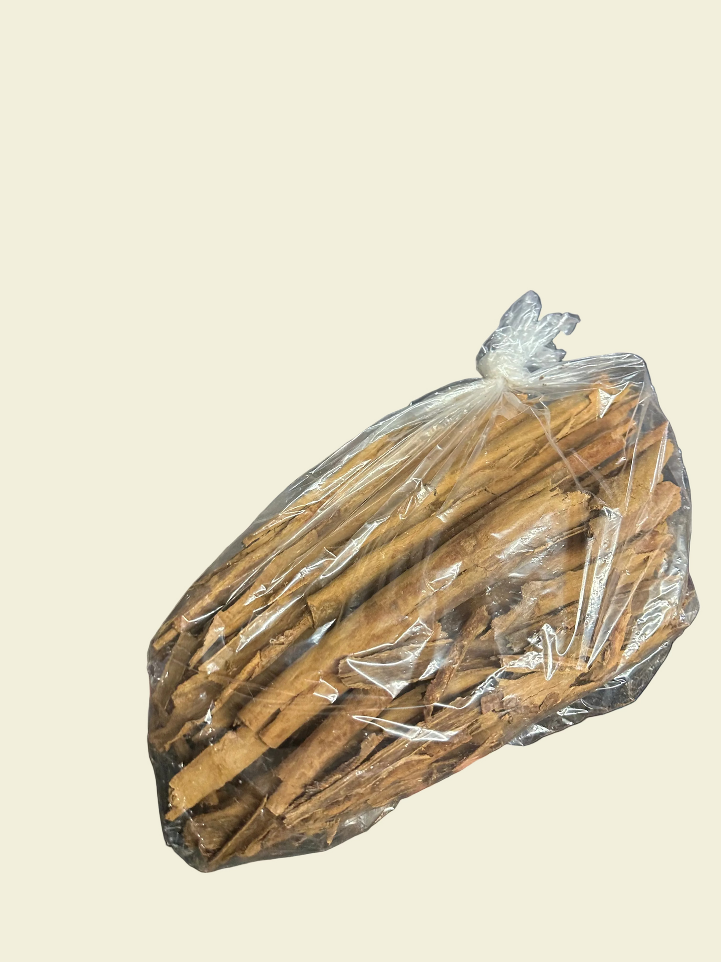Bunch of cinnamon sticks in clear plastic wrap held in a warehouse setting